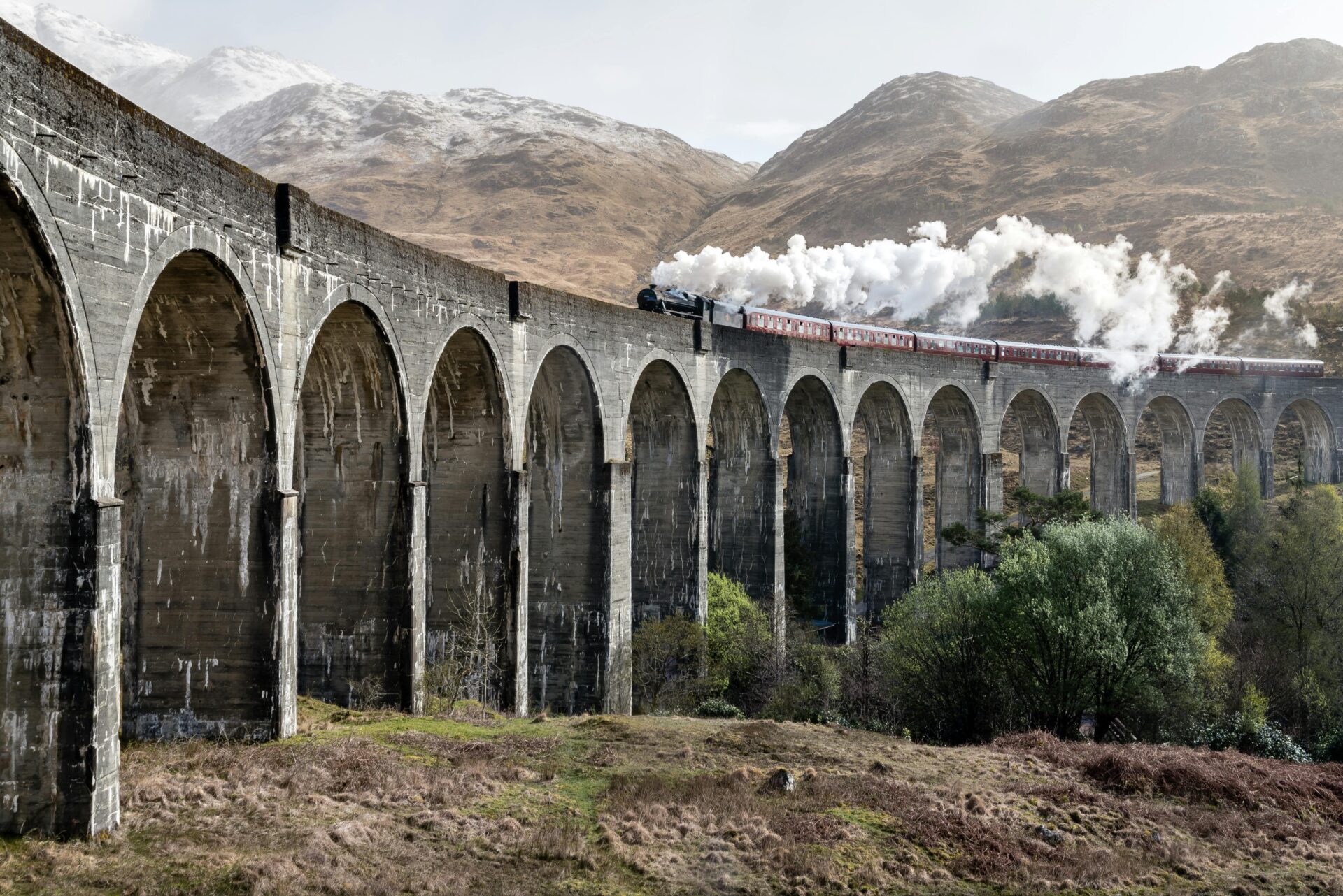 Scenic view of a steam train crossing the Glenfinnan Viaduct in the Scottish Highlands.